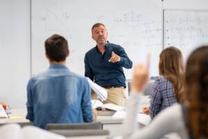 docent voor bord met wiskundeformules met leerlingen in klas