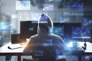 donkere afbeelding van jongen met hoodie op de rug gezien met allerlei computerschermen